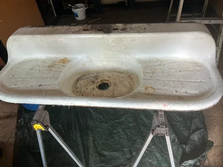 Rusted and stained vintage double drainboard sink before refinishing