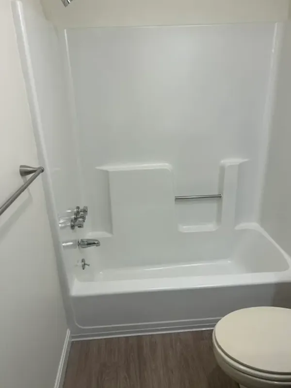 One-piece tub and shower unit after reglazing with a glossy white finish