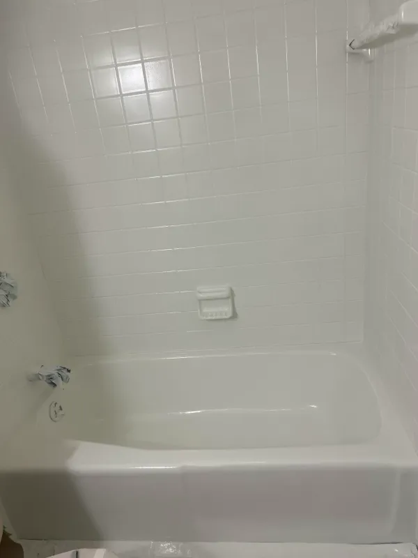 Bathtub and tile surround after reglazing with clean white finish